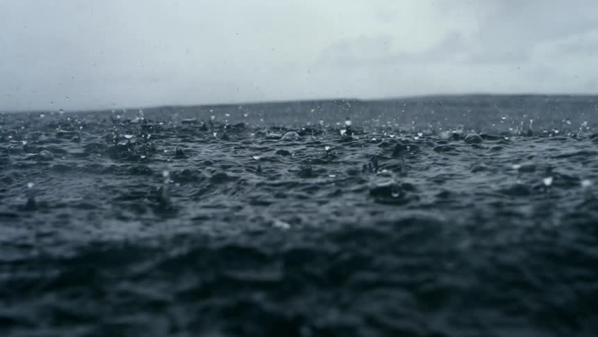 Rain falling on waves in the ocean