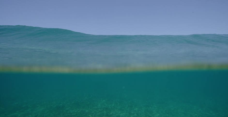Underwater with rocks and bubbles with the sky and clouds in the background
