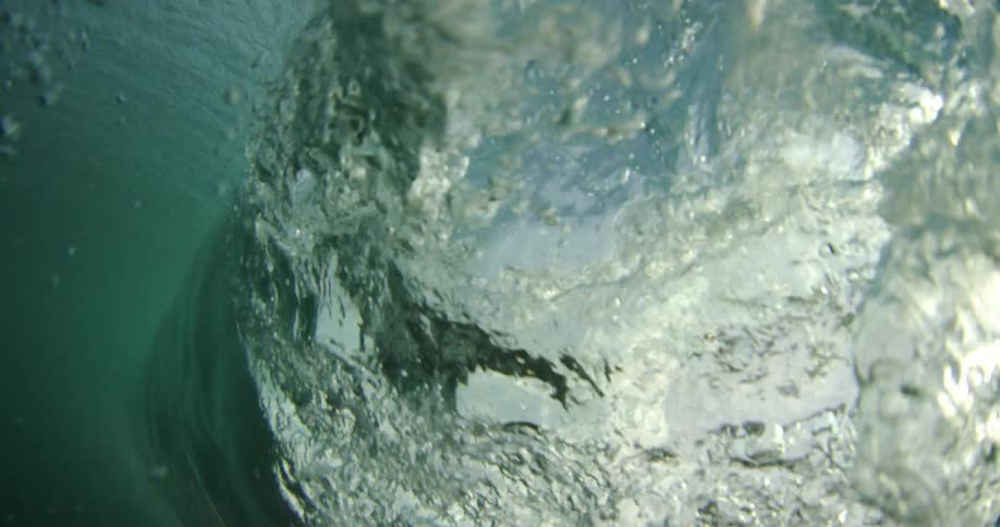 A surfer rides a large wave and then is underwater