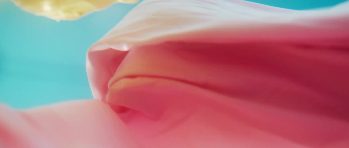 Yellow and pink fabric floating in turquoise water