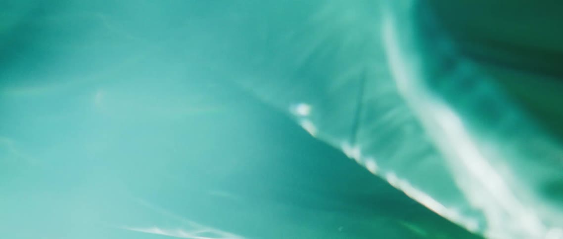 An abstract shot of material in water with the sun shining down