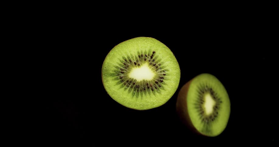 A knife slices a kiwifruit in half with a single quick slice