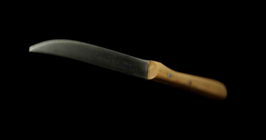 A knife spinning with a black background with light and reflection