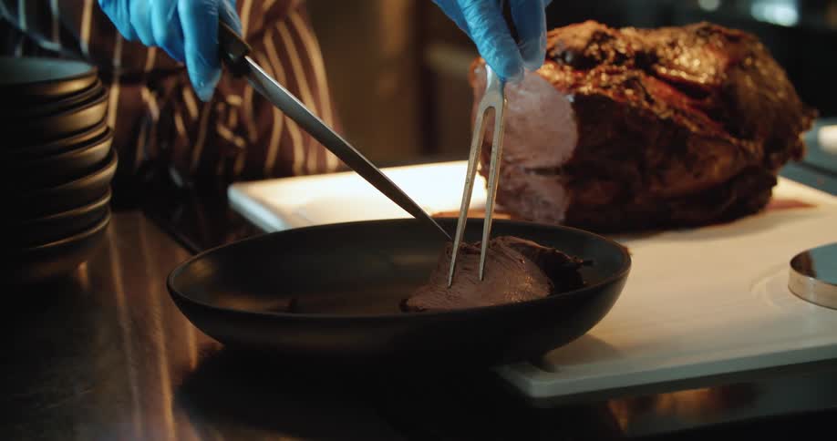 A chef preparing and carving meat