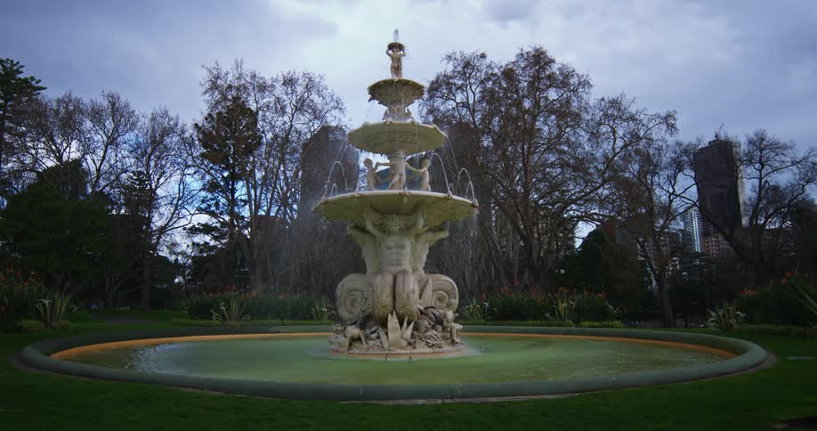 An elaborately carved water fountain spouts water outdoors during the day
