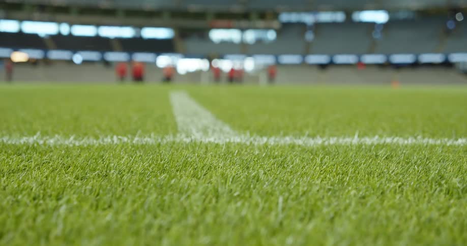 Astroturf and yard line on field inside large stadium