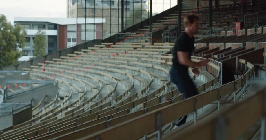 A man runs up the aisle of stadium bleachers