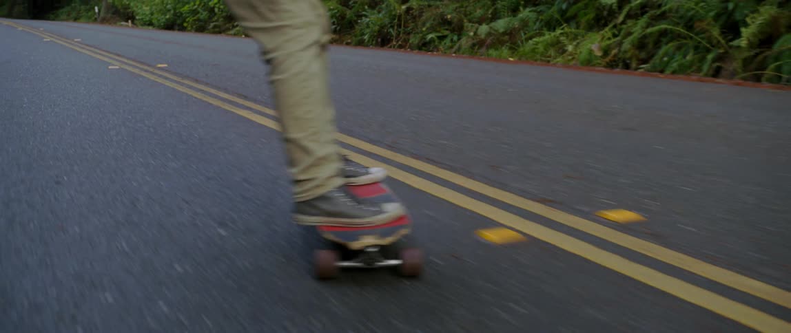 A person skateboards down a hill