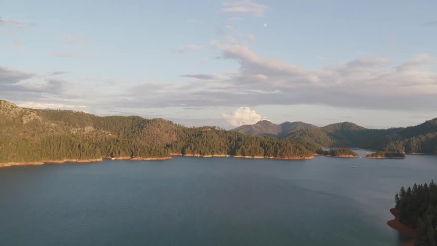 Clouds float above a mountain lake on a summer day