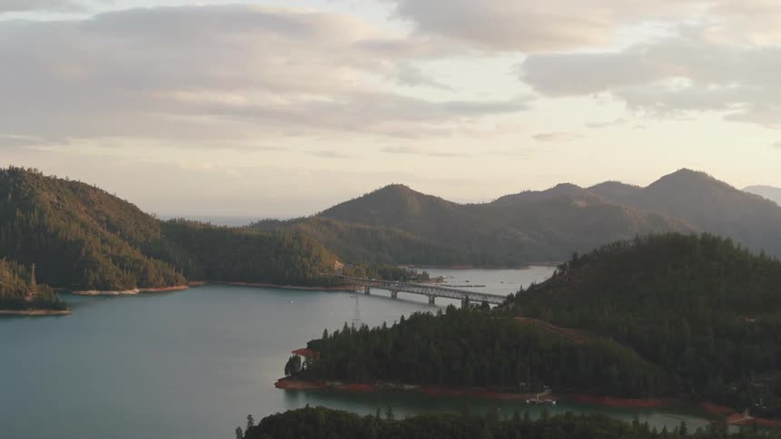 A bridge spanning a lake surrounded by hills