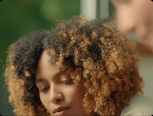 Two women talking with trees in the background