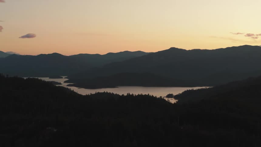 Distant river and mountains are silhouetted against the red sky