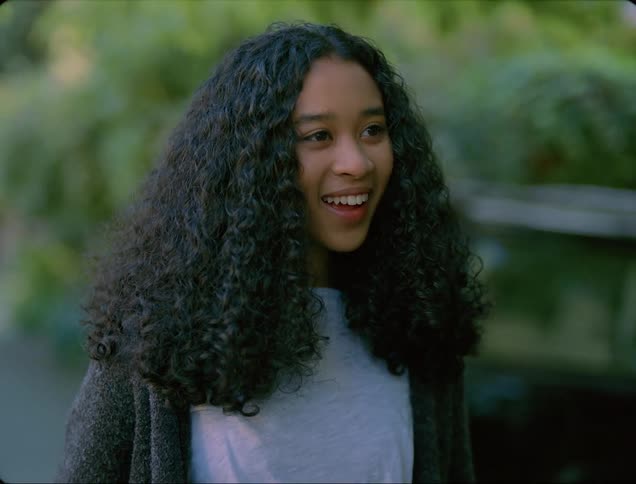 A girl greets someone outside
