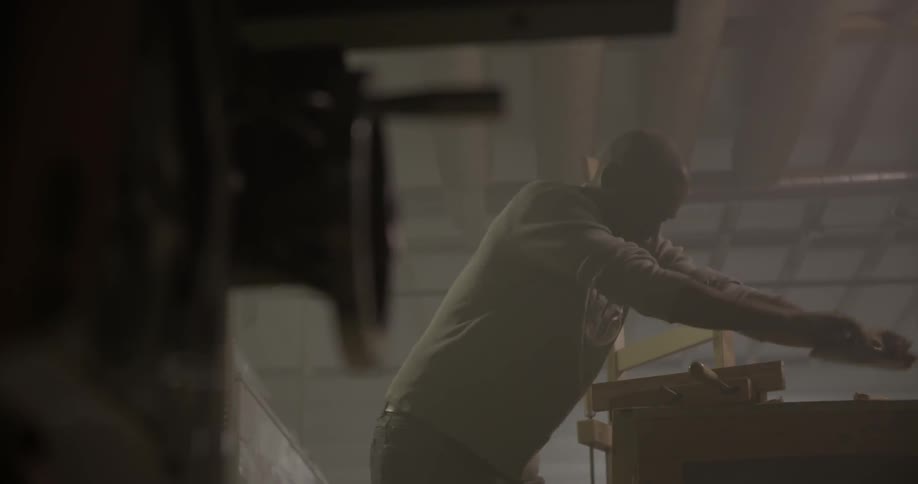 A man is working with a tool on a piece of wood