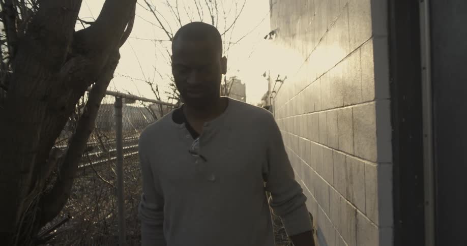 A man is walking outside by a building