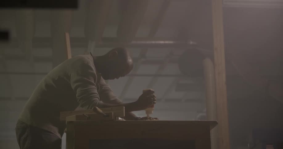 A man is working with tools on a bench