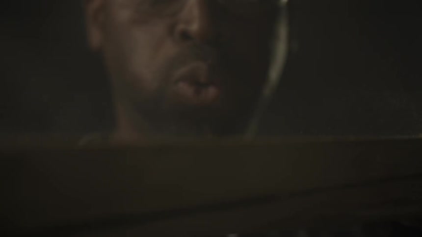 Dust is blown off a plank by a man
