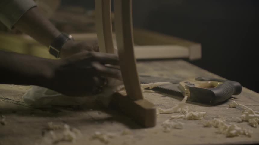 A man wiping glue from a chair