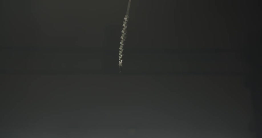 A hand reaches up to pull a chain and turn a light on