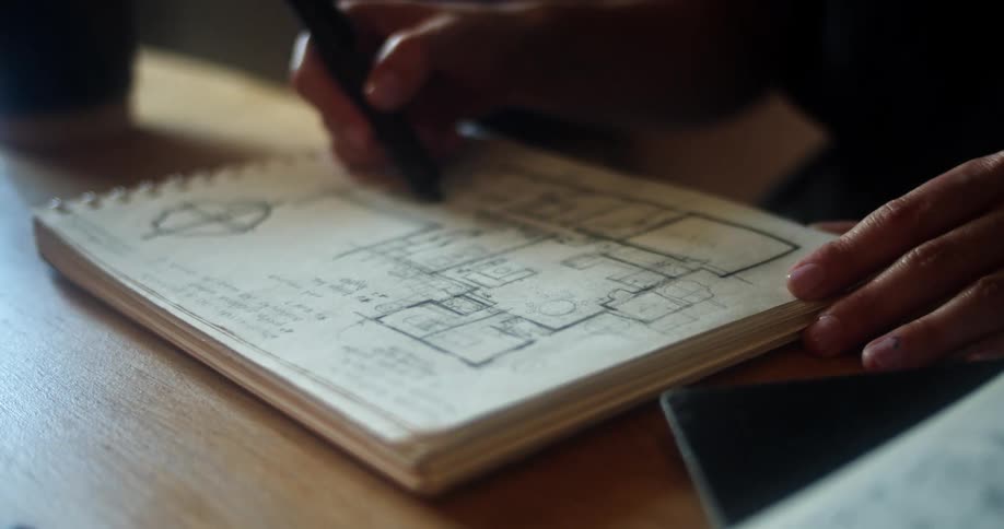 A woman in an office sketches a floor plan