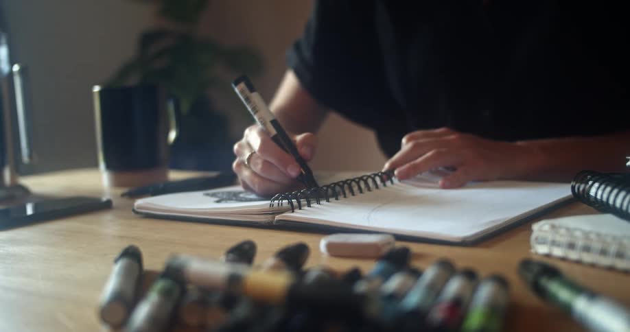 A woman is using a marker to draw in a book