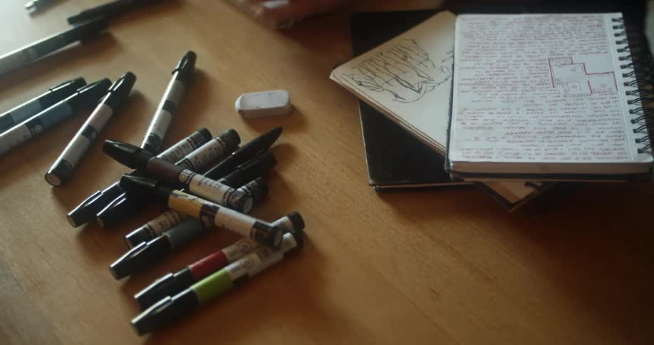 A person at the desk reaches for a marker