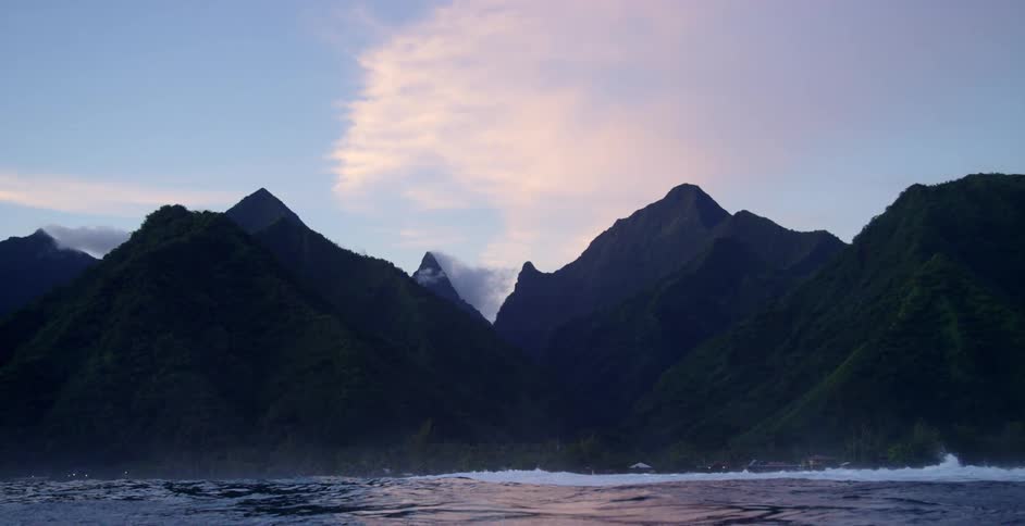 Waves crash against the mountain range