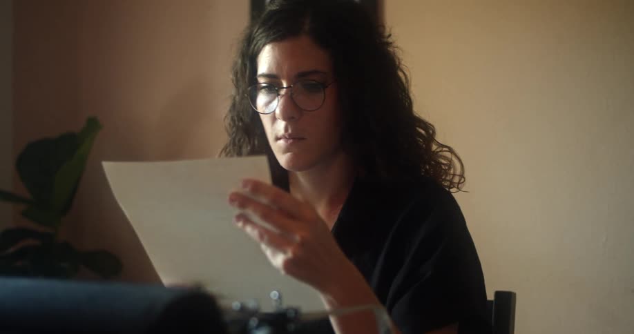 A woman is using an old typewriter
