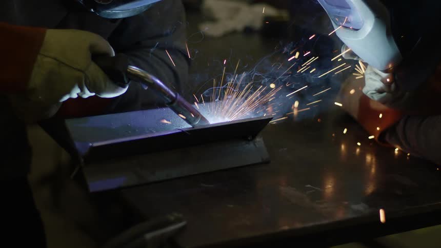 A person is welding a piece of metal