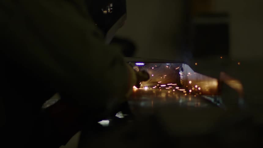 A man welding metal in a room