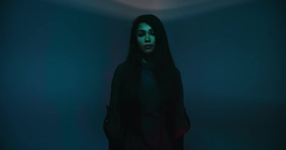 A woman standing in a room with lights and shadow