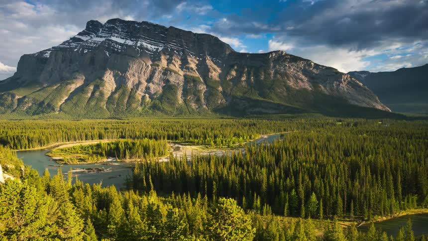 A river runs through a heavily forested mountain valley