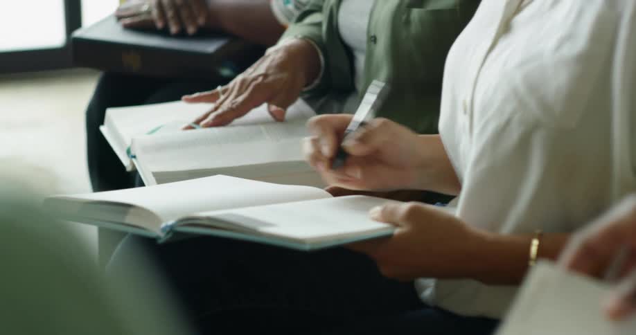 A group of people sit together with open books