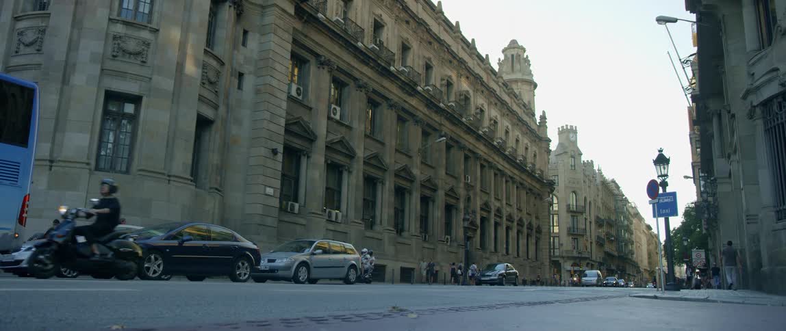 A city street with pedestrians vehicles and buildings