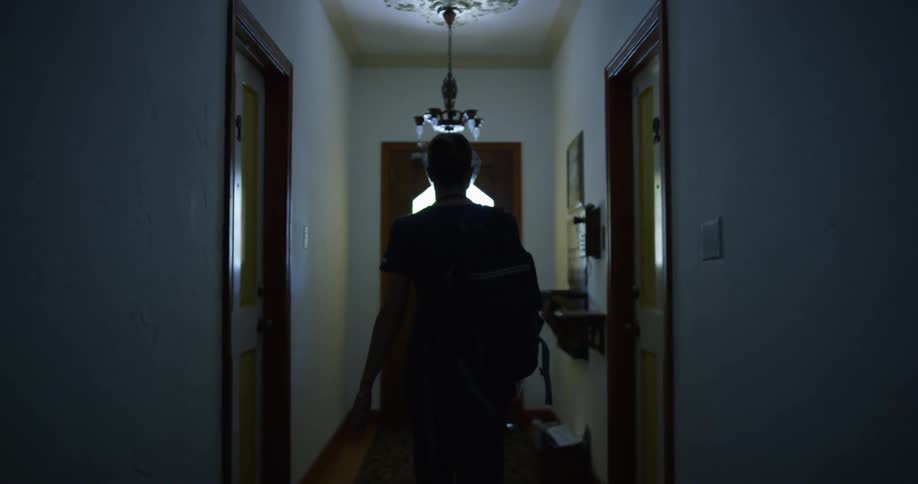 A woman is walking through a house