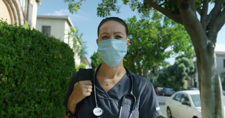 A nurse is standing on the sidewalk
