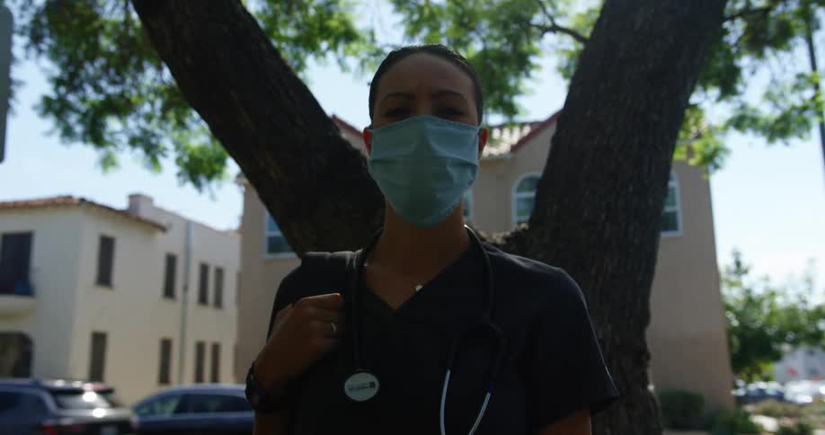 A nurse stands by a tree