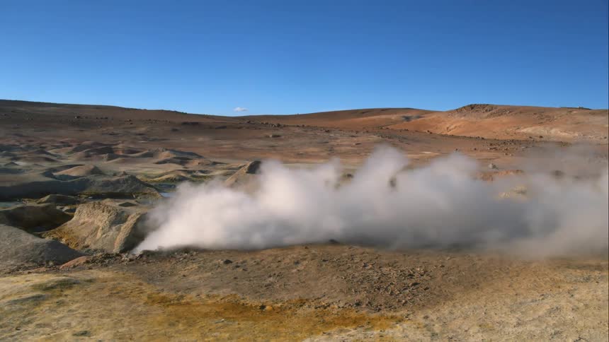 Steam billowing from the ground on a volcano