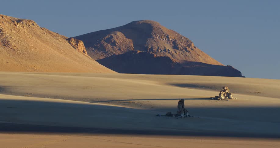 Two rock piles sit in a desert mountain valley