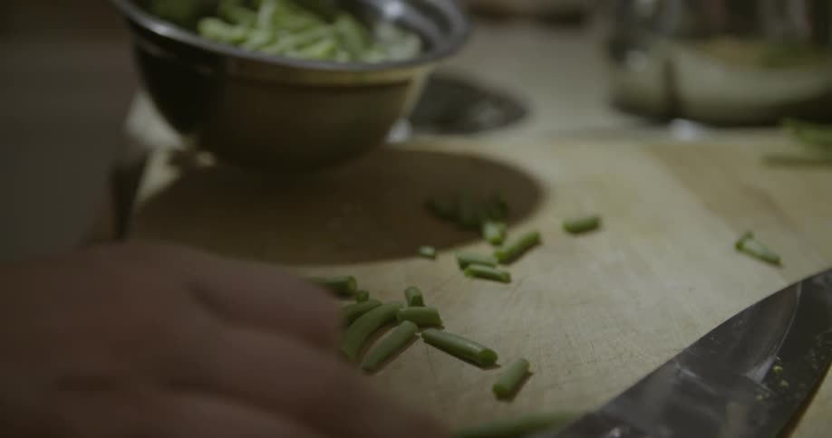 A woman is putting vegetables into a bowl