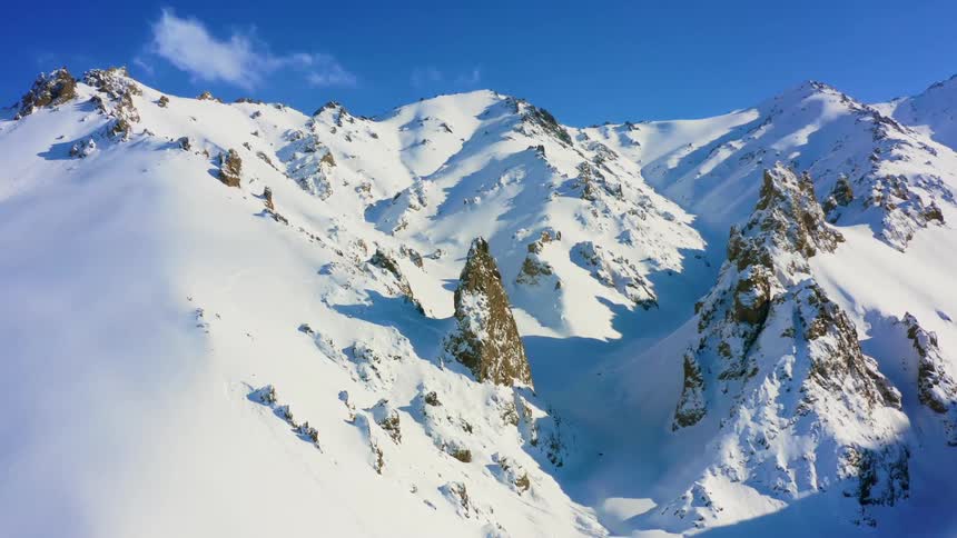 Aerial view of snow capped mountains against the blue sky