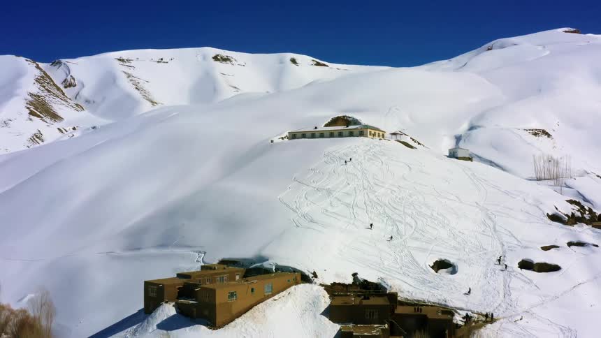 Flying away from a mountain where people are skiing
