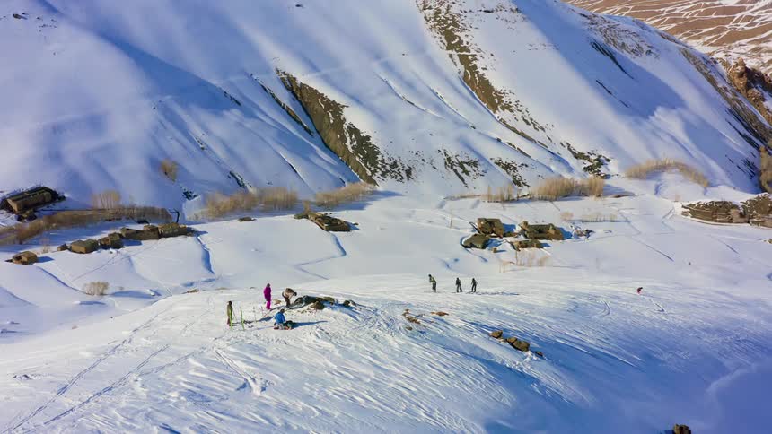 Three people are walking through the arctic