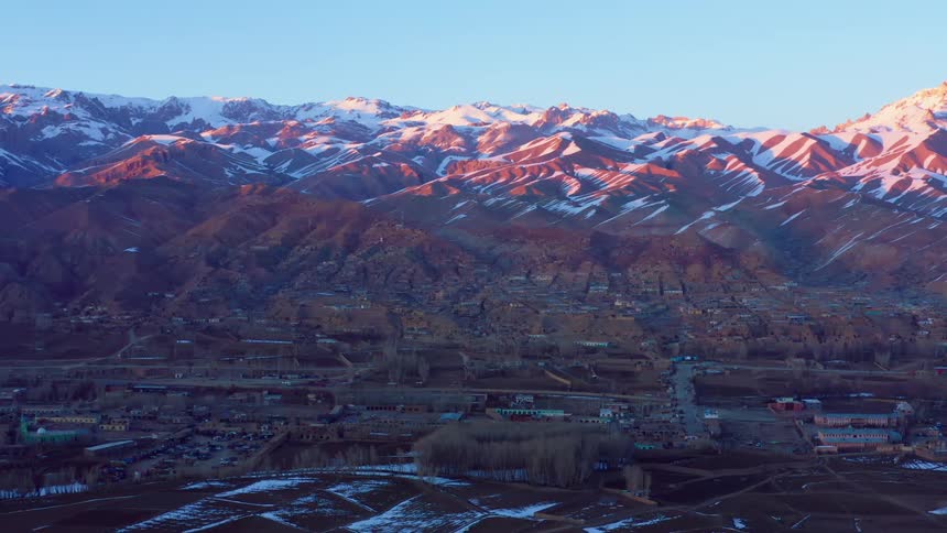 An aerial view of a neighborhood at the base of a mountain
