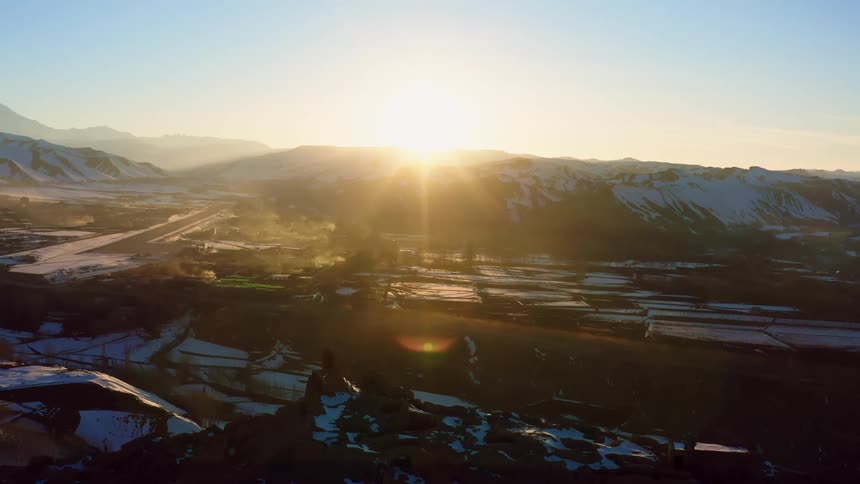 The sun is setting above the mountains