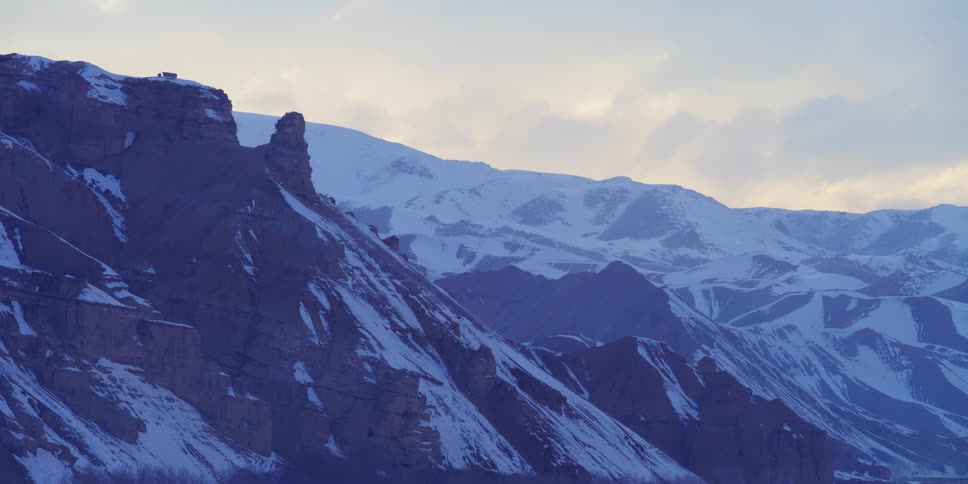 Clouds floating above a snowy mountain range on a winter day