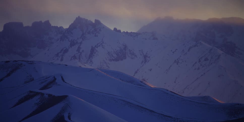 Snow covered rugged mountains at dawn