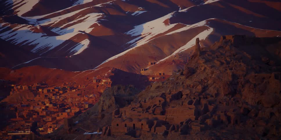 Buildings cover the slope of a mountain range
