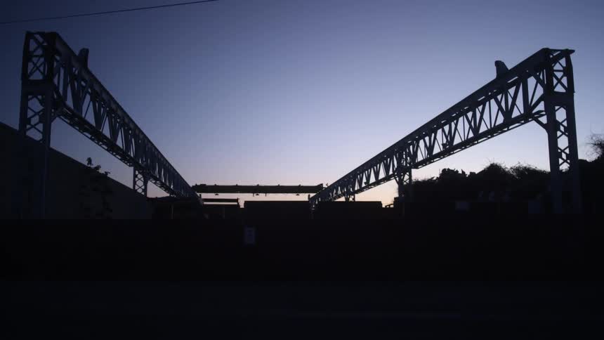 Parallel metal structures lead to wall at night under clear sky