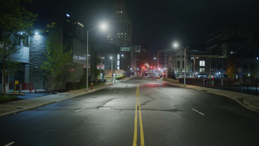 A four lane road downtown is deserted and quiet at night